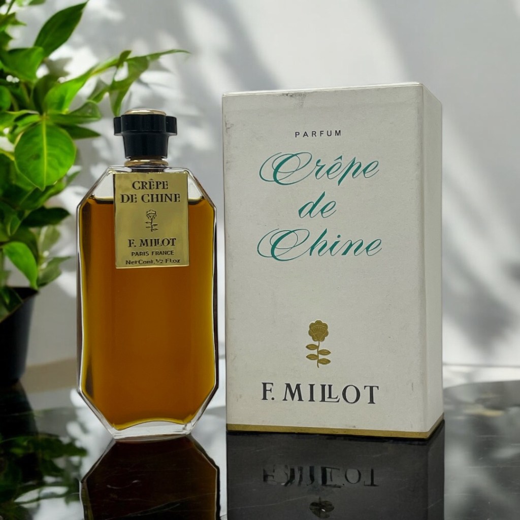 A bottle of perfume next to its box