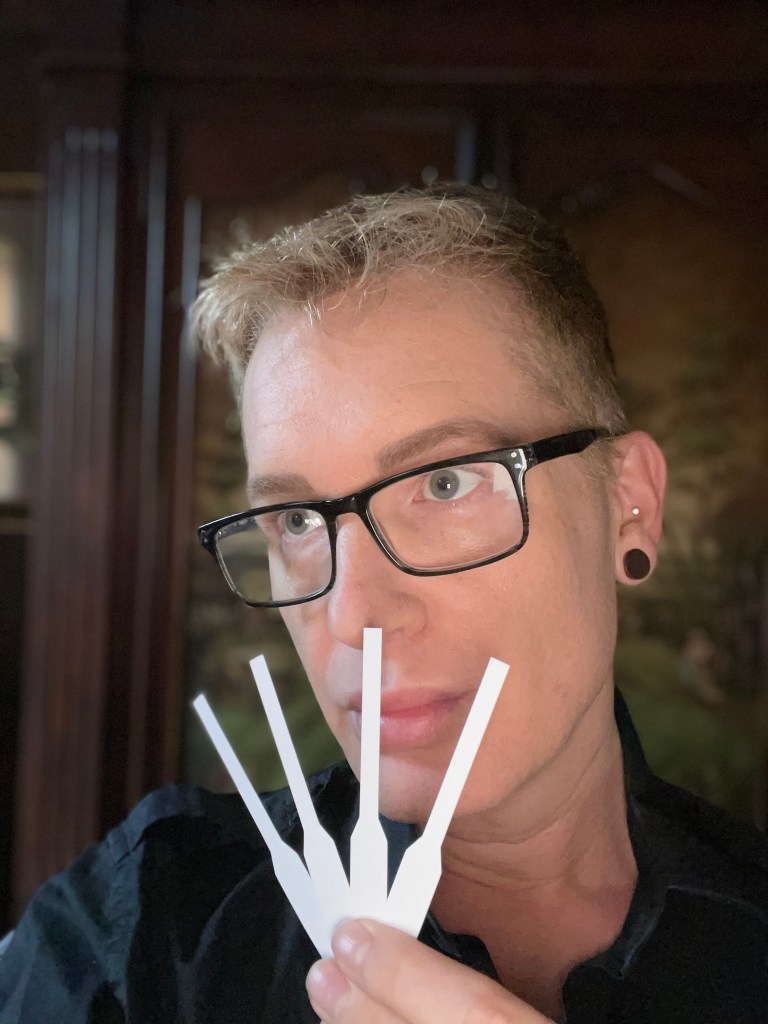 Headshot of Darren Alan sniffing perfume on blotters