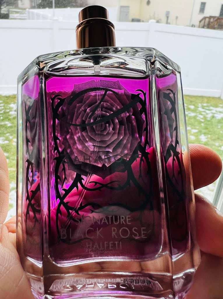 A bottle of perfume held in someone's hand