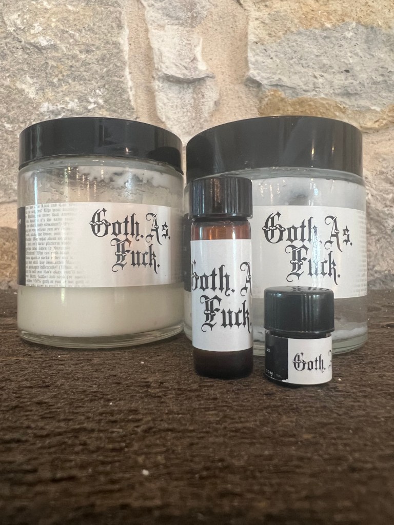 Various Goth as Fuck products set on a table