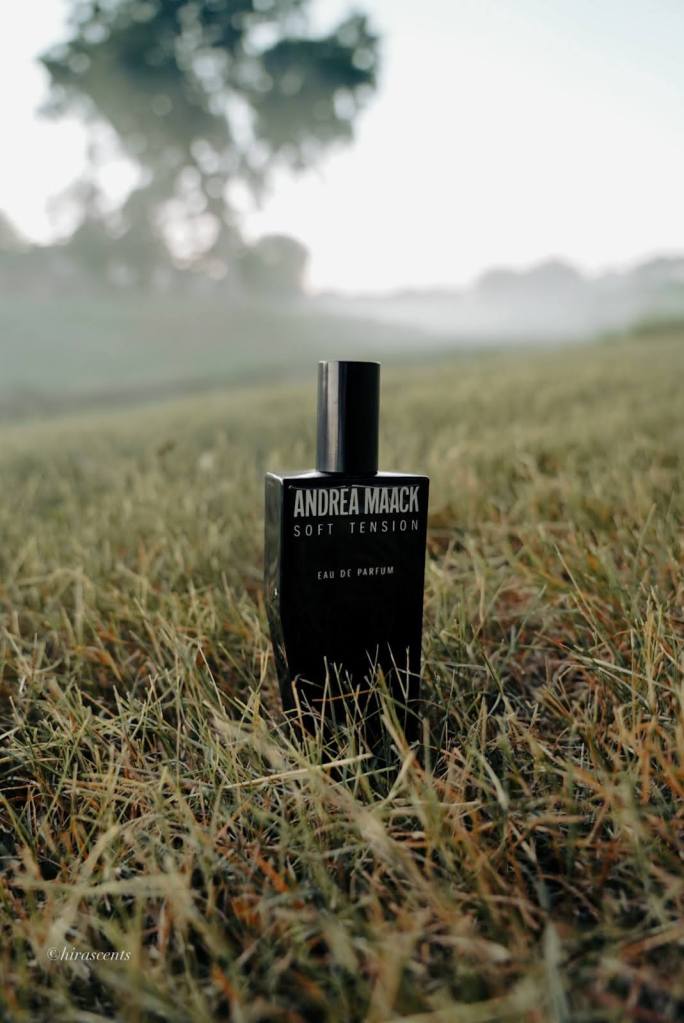 A perfume bottle in a field of grass